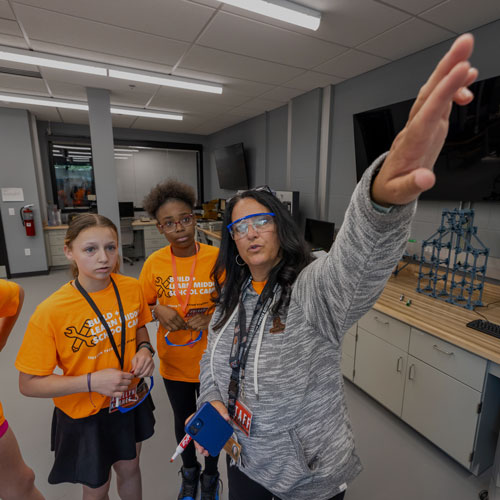 Instructor with students at a whiteboard