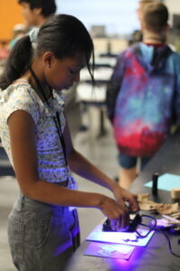 STEAM student curing resin with a black light