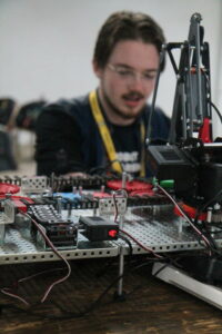 Student working on his robot at a table