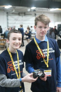 Two students holding their robot at the NRC